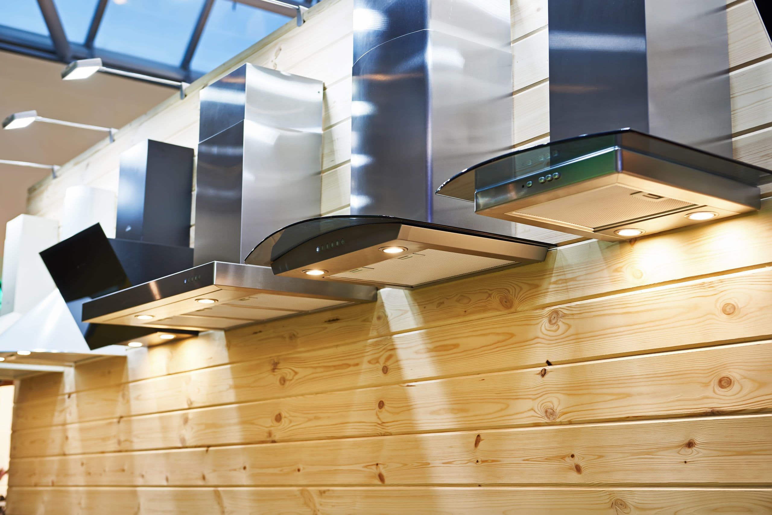 Stainless steel kitchen rangehood above a timber-clad wall